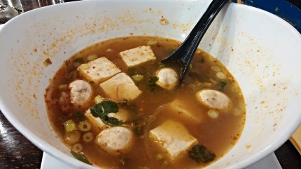 A big bowl of Tom Yum soup with tofu
